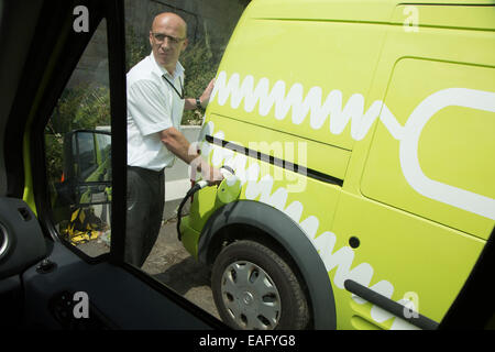 Man lädt einen elektrischen van in einem Depot Brighton Rat. Stockfoto