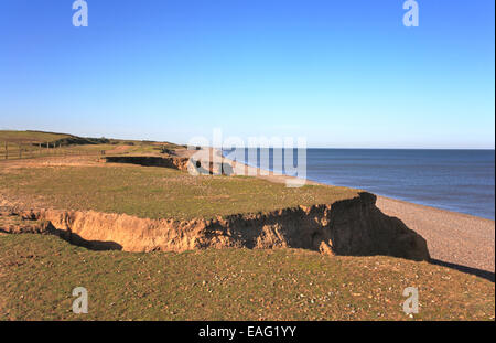 Ein Blick auf niedrige erodierenden Klippen hinter der Kiesstrand am Weybourne auf der North Norfolk Küste, England, Vereinigtes Königreich. Stockfoto