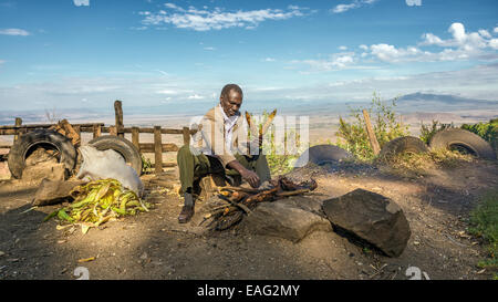 Afrikanischer Mann in einem Anzug verkauft Mais an der Kamandura Mai Mahiu Narok-Straße in der Nähe von Great Rift Valley in Kenia, Afrika Stockfoto