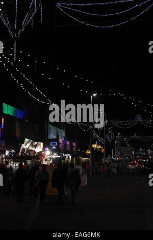 Nachtporträt LED "Bling Illuminations" über Menschen zu Fuß durch Fastfood-Neuheit Geschäfte, Seite Koralleninsel Arcade, Blackpool Stockfoto
