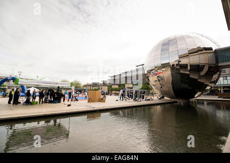 BRISTOL, Vereinigtes Königreich - 3. Juni 2014: Menschen genießen das Wetter gehen vorbei an der Edelstahl-Kugel des Planetariums, Mil Stockfoto