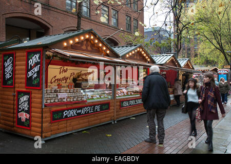 Händler Manchester UK, 14. November 2014. Schweine & Apfelkuchen aus dem Crusty Pie Company bei der Eröffnung Tag der Weihnachtsmarkt zieht Käufer aus dem Vereinigten Königreich und darüber hinaus. Besetzt festliche Weihnachten Ständen mit Geschenke, Dekorationen im Zentrum der Stadt. Stockfoto