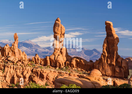 Drei 'Marching Men' Sandsteinsäulen vor die La Sal Mountains im Klondike Bluffs Bereich des Arches National Park, Uta Stockfoto