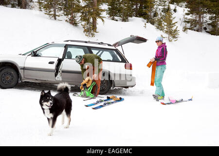 Zwei Backcountry Skifahrer setzen Sie auf ihre Haut vor der Überschrift im Bienenstock-Becken in der Nähe von Big Sky, Montana. Stockfoto