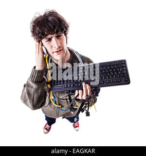 ein lässig Kerl mit Kabelsalat und eine Tastatur ringt Computer Hilfe bekommen. isoliert auf weiss Stockfoto