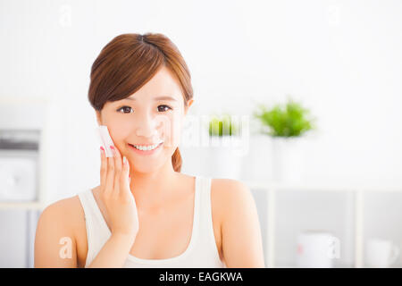 Schöne junge Asiatin reinigen ihr Gesicht mit Baumwolle Stockfoto