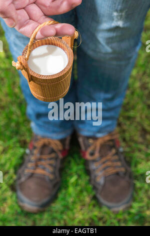 Frauen halten kleine hölzerne Becher Milch Stockfoto