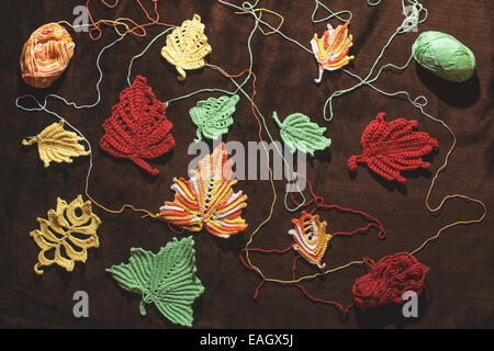 Gestrickte Herbstlaub auf braun Textil Stockfoto
