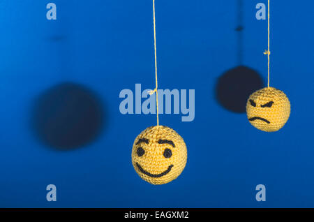 Gestrickte gelbe Emoticons auf blauem Hintergrund Stockfoto