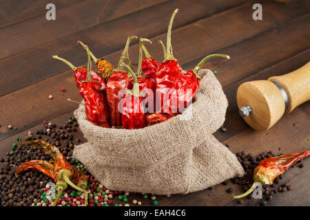 rote Chilischoten in meschotschek Leinwand auf Holztisch Stockfoto