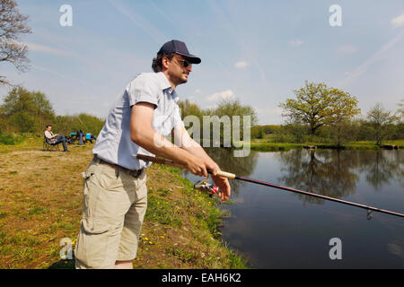 Fischer bei einem Fischteich mit Angeln Rute in der hand Stockfoto