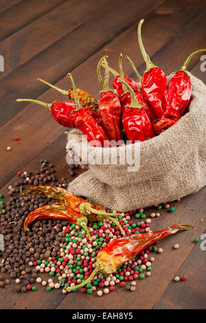 rote Chilischoten in meschotschek Leinwand auf Holztisch Stockfoto