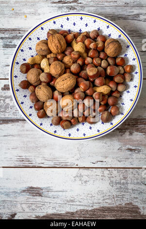 Nüssen, Erdnüsse, Walnüsse, sortiert in einer weißen Schale auf weißer Holztisch Stockfoto