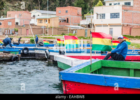 Junger Mann sitzt am Fluss Fähre an der Meerenge von Tiquina, Bolivien. Die Fähren nehmen Autos, LKWs, Busse und Motorräder. Stockfoto