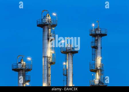 Detail der vier Türme der Destillation in einer Chemiefabrik und Raffinerie mit blauen Nachthimmel. Stockfoto