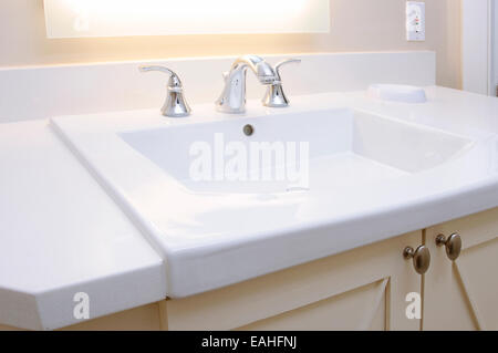 Waschbecken im Badezimmer und Zähler: Nahaufnahme eines Badezimmer Waschbecken, Chromhahn und weiße Theke. Stockfoto