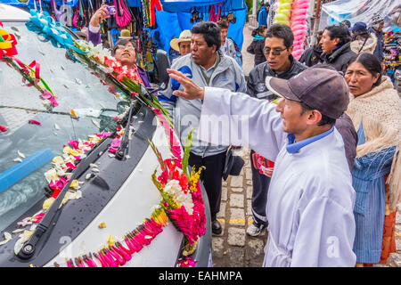 Ein katholischer Priester segnet einen van für die jährliche Segnung der Fahrzeuge auf die Hauptkirche in Copacabana, Bolivien dekoriert. Stockfoto