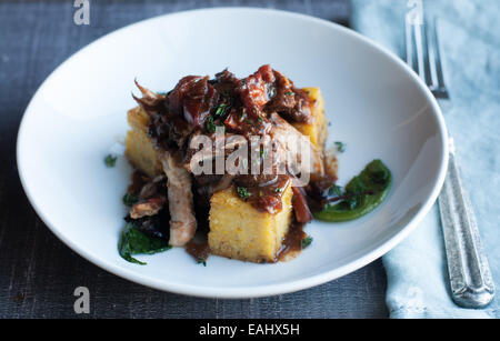 Polenta mit Balsamico geschmortes Huhn mit leckeren saisonalen sautierten greens Stockfoto