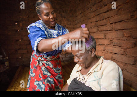 Eine Frau sorgt für einen älteren kranken Patienten zu Hause in Mulanje Bezirk, Malawi. Stockfoto