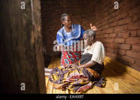 Eine Frau sorgt für einen älteren kranken Patienten zu Hause in Mulanje Bezirk, Malawi. Stockfoto