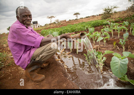 Ein Kleinbauer bewässert seiner pflanzlichen Farm in Makueni County, Kenia, Ostafrika. Stockfoto