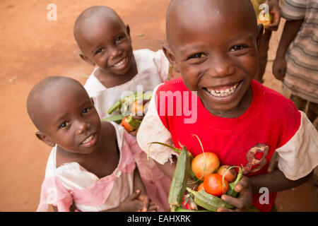 Kinder halten Sie frisch geerntete Gemüse in Makueni County, Kenia, Ostafrika. Stockfoto