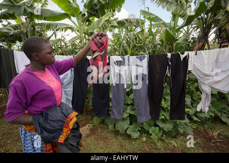Eine Frau hängt ihre Wäsche ihr Wäscheleine im Bukwo District, Uganda, Ostafrika. Stockfoto