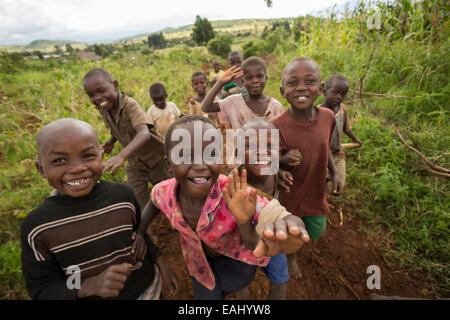 Glückliche Kinder laufen zusammen auf einer ländlichen Straße in Bukwo District, Uganda. Stockfoto