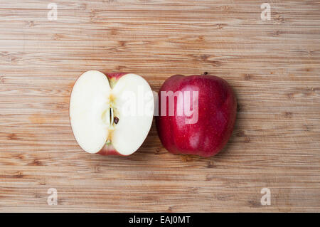Frischer Apfel in Scheiben in der Mitte auf einem Holzbrett Stockfoto