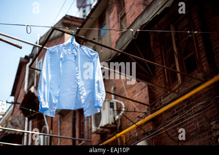 Blaues Hemd hängt eine Wäscheleine in einer traditionellen Gasse in der Altstadt von Shanghai Stockfoto