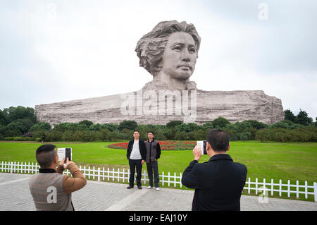 Chinesische Touristen posieren vor der weltweit größte Statue von Mao Zedong in Changsha, China Stockfoto