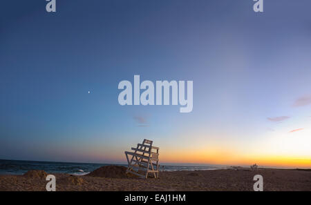 Sommer in den Hamptons. Ponquogue Strand, Hampton Bays, New York blaue Stunde Sonnenuntergang Rettungsschwimmer Stühle, Splitter von dem Mond, Venus. Stockfoto