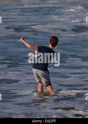 Junge skimming Steinen im Meer, Bude, Cornwall, UK Stockfoto