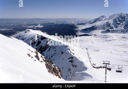 Skipisten und Sessellift auf Hala Gasienicowa im Tatra-Gebirge in Polen mit den weit Blick der Region Podhale. Stockfoto