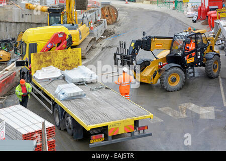 Luftaufnahme Bauplatz Gabelstapler zum Entladen Pritsche Lieferung LKW Arbeiter tragen harten Hut & hohe Sichtbarkeit Jacke London UK Stockfoto