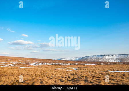 Großer blauer Himmel über einer Moorlandschaft mit Ende des Winterschnee und bunten Moorland Gräser. Stockfoto