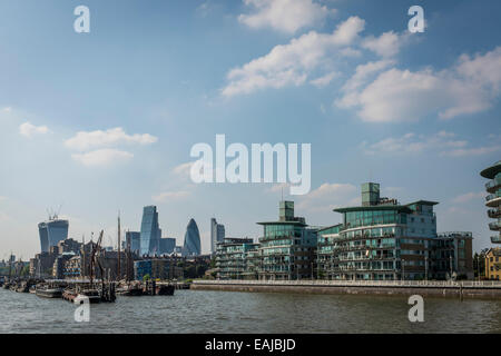 Blick von einem Boot der modernen riverside Apartments im Wapping am Nordufer der Themse mit der Stadt hinter. Stockfoto