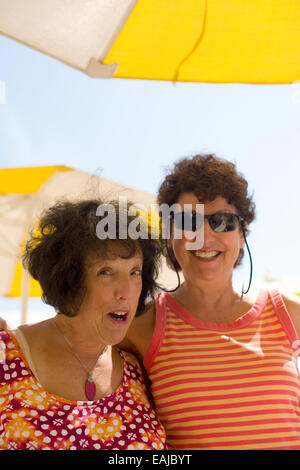 zwei pensionierte alte Frauen lange Zeit alte Freunde glücklich am Strand Lachen und scherzen Stockfoto