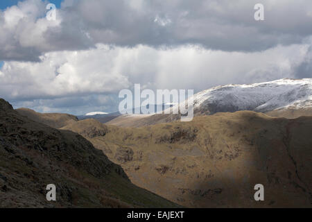 Sturm & Dusche Wolken über Schnee begrenzt Gipfel des Lakelandpoeten von Gibson Knott entlang von Helm Crag über Grasmere Stockfoto