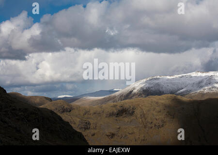 Sturm & Dusche Wolken über Schnee begrenzt Gipfel des Lakelandpoeten von Gibson Knott entlang von Helm Crag über Grasmere Stockfoto