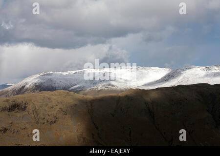 Sturm & Dusche Wolken über Schnee begrenzt Gipfel des Lakelandpoeten von Gibson Knott entlang von Helm Crag über Grasmere Stockfoto