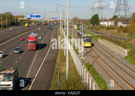 Metrolink tram neben Autobahn M60 auf der Flughafen-Linie, Manchester, England, UK Stockfoto