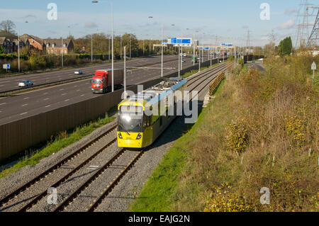 Metrolink tram neben Autobahn M60 auf der Flughafen-Linie, Manchester, England, UK Stockfoto