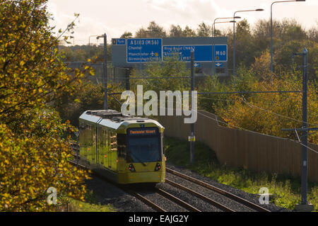 Metrolink tram neben Autobahn M60 auf der Flughafen-Linie, Manchester, England, UK Stockfoto