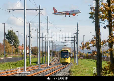 Digitale Montage eines Flugzeugs über eine Metrolink-Straßenbahn auf der Flughafen-Linie in der Nähe von Manchester Airport.  Manchester, England, Vereinigtes Königreich Stockfoto