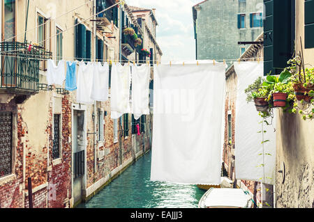 Hängende Kleidung zum Trocknen über einen Kanal in Venedig, Italien. Stockfoto