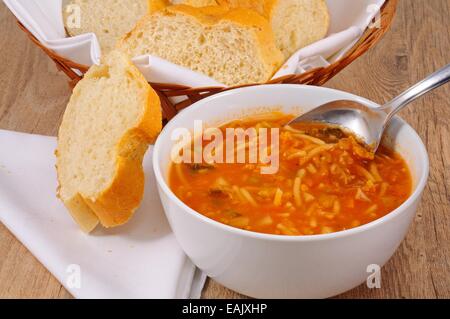 Hausgemachte vegetarische Minestrone-Suppe mit Brot serviert. Stockfoto