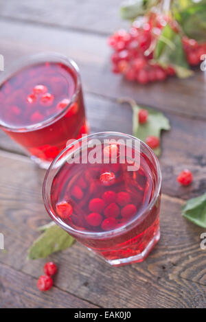 Viburnum Getränk im Glas und auf einem Tisch Stockfoto