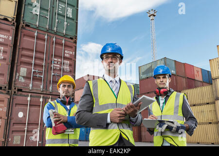 Unternehmer tragen Schutzkleidung in der Nähe von Containern Stockfoto