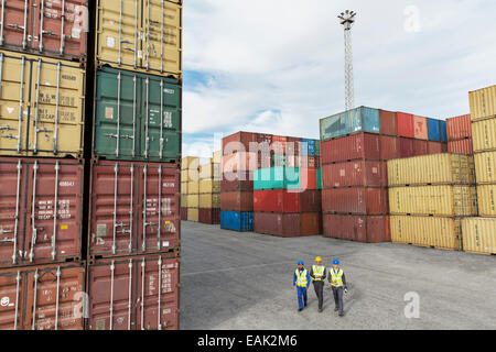 Unternehmer und Arbeitnehmer, die zu Fuß in der Nähe von Containern Stockfoto